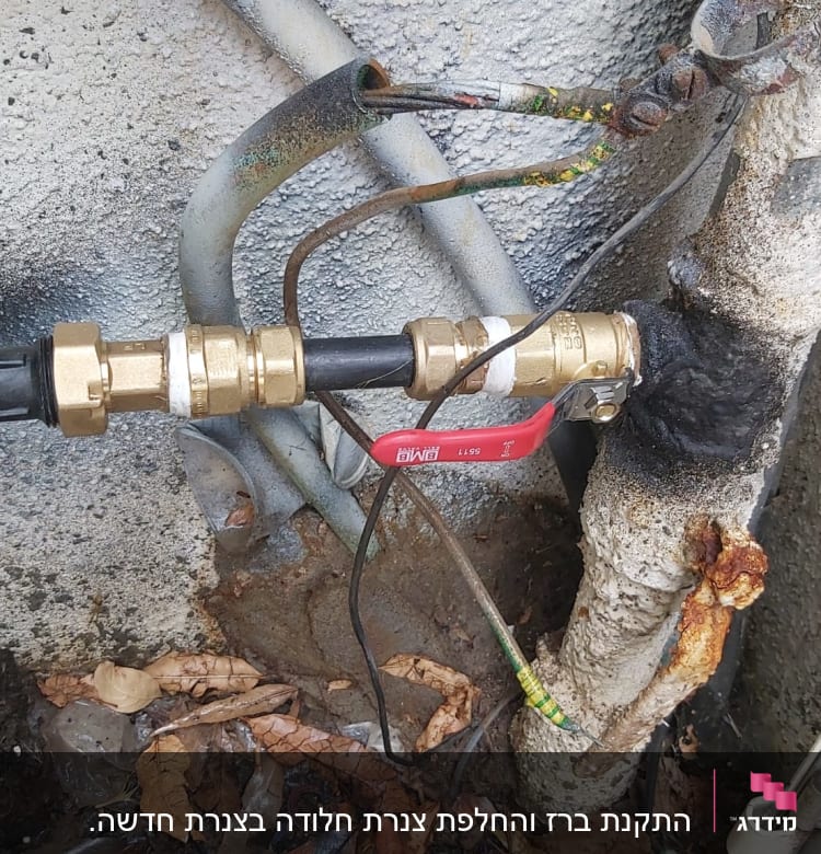 שסתום פליז עם ידית אדומה בצנרת מים